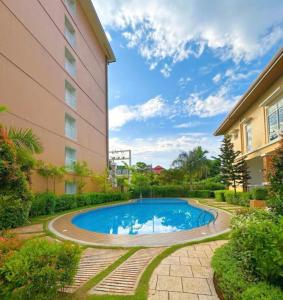 a swimming pool in front of a building at Camella Verdant - Dolcevita Residence in Puerto Princesa City