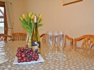 a table with a bottle of wine and wine glasses at Cotterton Beag in Nethy Bridge