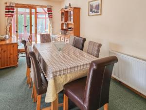 a dining room table and chairs with a table and a table at Cotterton Beag in Nethy Bridge