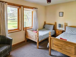 a bedroom with two beds and a window at Cotterton Beag in Nethy Bridge +4 photos
