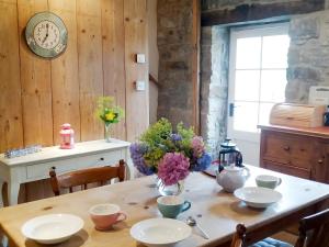 a wooden table with a vase of flowers on it at Corner Cottage in Bakewell