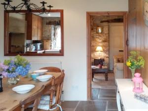 a dining room with a table and a mirror at Corner Cottage in Bakewell