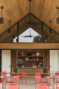 a dining room with red chairs and tables and a ceiling at Three Ducks in Westhampton
