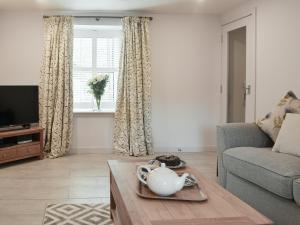 a living room with a couch and a table at Rowanlea in Muthill