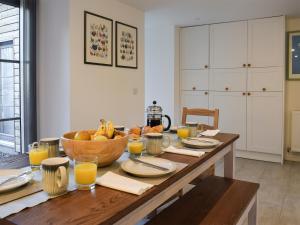 a table with a bowl of fruit and glasses of orange juice at Rowanlea in Muthill
