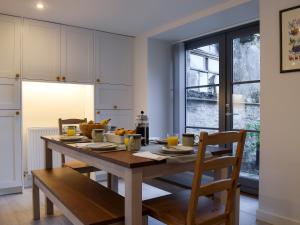 a kitchen with a wooden table and chairs and a window at Rowanlea in Muthill +17 photos