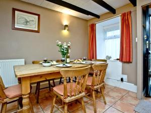 a dining room with a wooden table and chairs at Pilgrims Cottage in Brixham