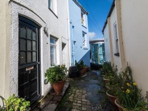 an alley between two buildings with potted plants at Pilgrims Cottage in Brixham +9 photos