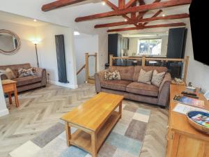a living room with two couches and a table at Mallard Cottage in Penrith