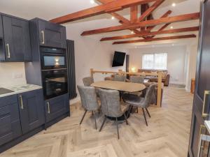 a kitchen and dining room with a table and chairs at Mallard Cottage in Penrith