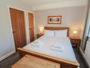 a bedroom with a large white bed with two pillows at Mallard Cottage in Penrith +40 photos