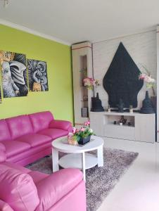 a living room with a pink couch and a table at Umah kampung8 in Mataram