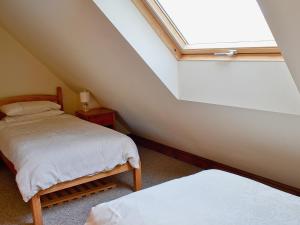 a attic bedroom with two beds and a skylight at Jasmine Cottage - 30503 in West Firle +5 photos