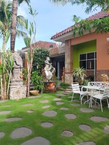a patio with chairs and a statue in front of a house at Umah kampung8 in Mataram