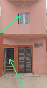 a person looking out of a window of a pink building at El Shaddai I in Santiago del Estero