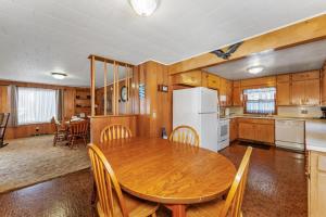 a kitchen with a wooden table and a white refrigerator at Eagle Villa At Otter Cove in Eagle River