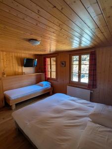 a bedroom with two beds in a wooden cabin at L'Auberge de la Combal in La Comballaz
