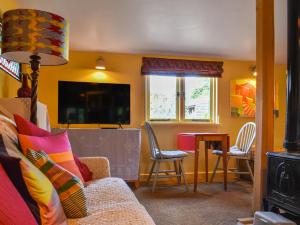 a living room with a couch and a table with chairs at Owls Nest in Stradbroke