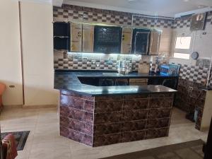 a kitchen with black counter tops and brown tiles at Charming blue see view apartment in Alexandria