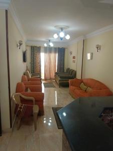a living room with couches and chairs and a table at Charming blue see view apartment in Alexandria