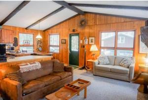 a living room with a couch and a table at Creekside Big St Germain Lake in Saint Germain