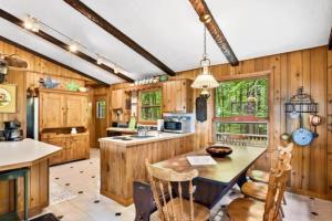 a kitchen with wooden walls and a table and chairs at Creekside Big St Germain Lake in Saint Germain +22 photos