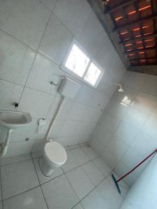 a bathroom with a toilet and a sink at Casa no Paracuru in Paracuru