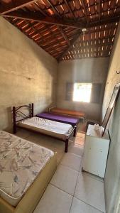 a room with two beds and a window at Casa no Paracuru in Paracuru