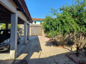 a car parked in front of a house with a fence at Casa no Paracuru in Paracuru