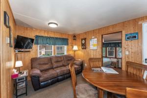 a living room with a couch and a table at Loons Landing Legacy in Saint Germain