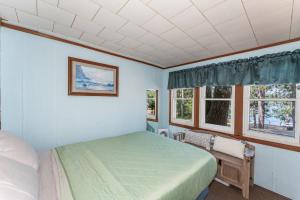 a bedroom with a bed and two windows at Loons Landing Legacy in Saint Germain