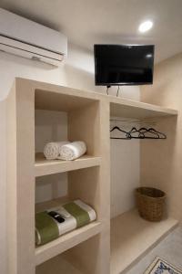 a room with shelves with a tv and towels at Chulel Hotel Origen in Cedro