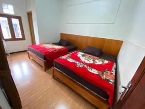 a room with two beds in a room at DIENG GHUZY HOUSE syariah family room 3 kamar in Wonosobo
