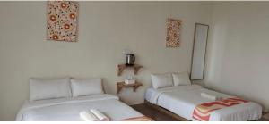 a room with two beds and a small table at DamaiiKu in Cherating