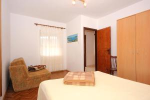 a bedroom with a bed and a chair at Apartment Rogacic 2460b in Vis