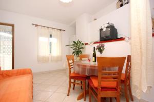 a dining room with a table and chairs and a tv at Apartment Rogacic 2460b in Vis