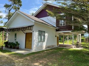 a small white house with a brown door at Suri Homestay, Taiping in Taiping