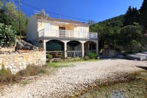 a house with a balcony on the side of a road at Apartment Rogacic 2460a in Vis