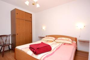 a bedroom with a bed with a red bag on it at Apartment Rogacic 2460a in Vis