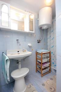 a bathroom with a white toilet and a sink at Apartment Rogacic 2460a in Vis