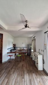 a living room with a ceiling fan and a kitchen at noemi apartments samara beach A-2 in Sámara