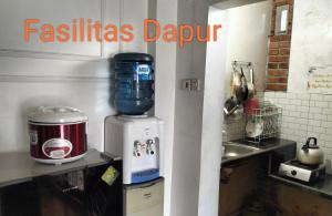 a kitchen with a mixer on a counter next to a sink at DIENG GHUZY HOUSE syariah family room 3 kamar in Wonosobo