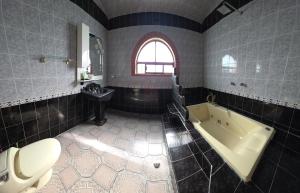 a bathroom with a tub and a toilet and a sink at Casa Quijote in Chiautla +18 photos