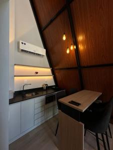 a small kitchen with a table and a sink at Âmbar Chalés in Ametista do Sul +3 photos
