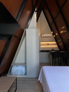 a bedroom with a white bed and a dining room at Âmbar Chalés in Ametista do Sul