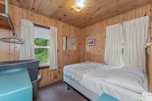 a bedroom with a bed and a window at TB5 Thunder Bay Resort Cabin5 in Phelps