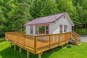 a small white house with a large wooden deck at TB5 Thunder Bay Resort Cabin5 in Phelps +5 photos