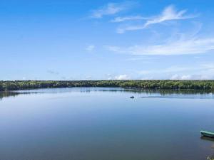 a large lake with a boat on the water at Bayview Resort Waters Edge Cabin 2 in Saint Germain