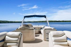 a pontoon boat sitting on a body of water at Bayview Resort Waters Edge Cabin 2 in Saint Germain