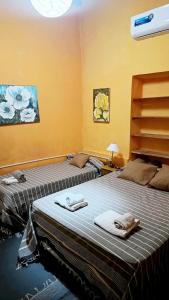 two beds sitting next to each other in a room at Hostal del Cerro in Belén